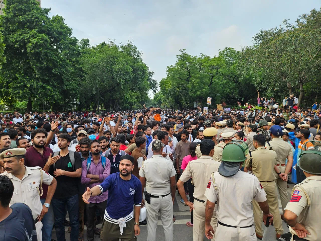 Crowd facing a police line